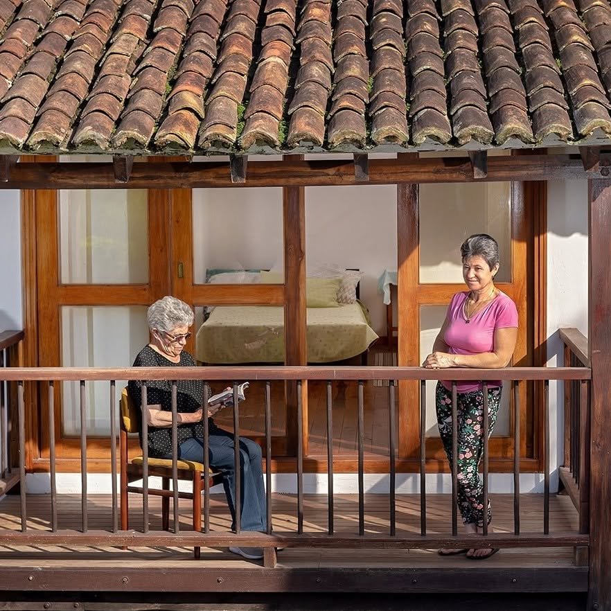 Dos residentes en el balcón de madera de la casa