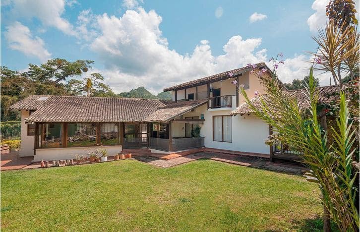 Casa principal con prado verde y jardín